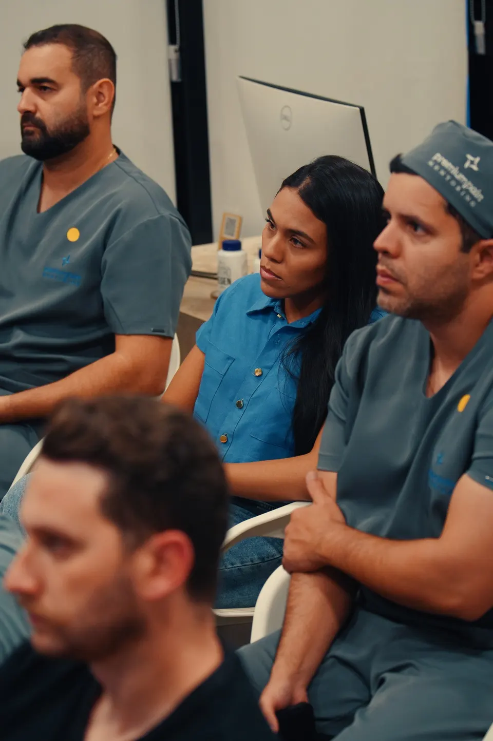 Médicos participantes acompanham discussão em sala