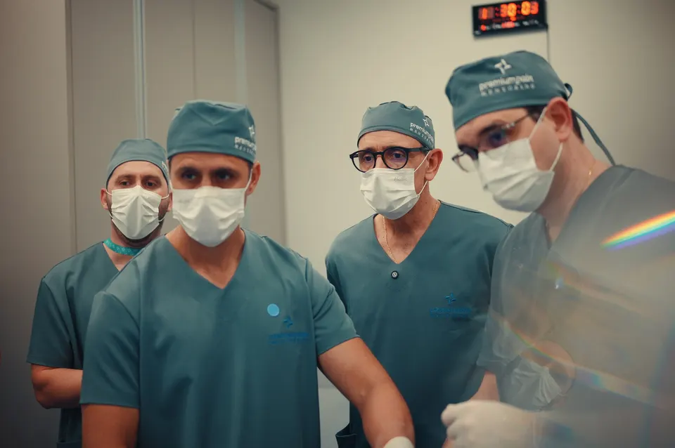 Grupo de médicos observa demonstração prática com equipamento